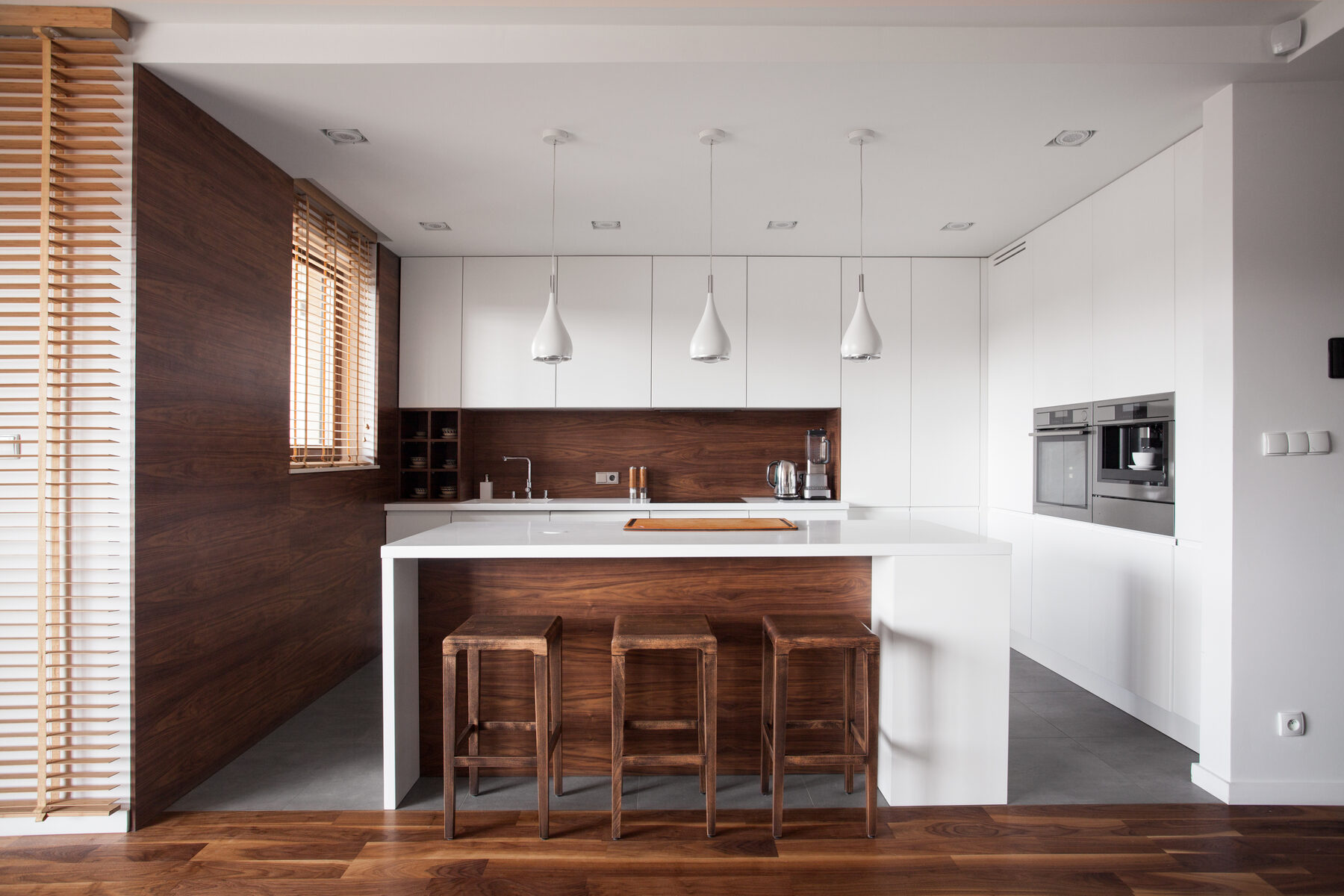 A modern kitchen with black cabinetry and a timber island